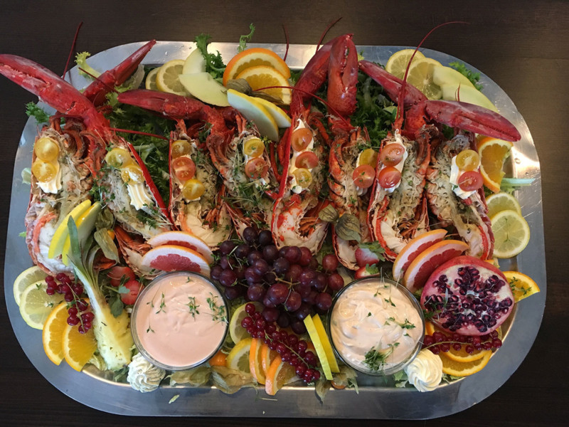 Üppig angerichtete Hummerplatte mit Früchten und Dips